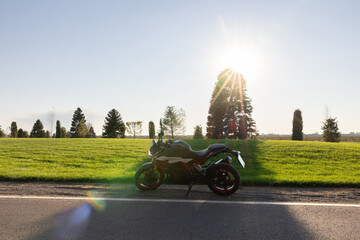 Sport motorcycle on a scenic road with a sunburst