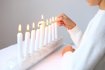 the ritual of lighting candles on the menorah during Hanukkah. The flames flicker gently, casting a warm glow that symbolizes hope and miracles. This cherished tradition brings families together