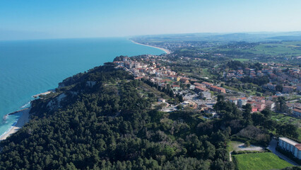 Fototapeta premium Panoramic shot capturing Numana's hilltop setting, white buildings contrasting azure Adriatic waters, representing scenic beauty of Conero Riviera in Le Marche, Italy