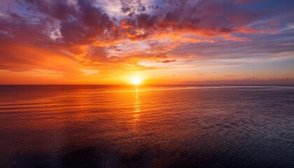 Obraz premium Beautiful Orange And Red Hues Paint The Sky As The Sun Dips Below The Horizon Casting A Golden Reflection On The Calm Ocean Water