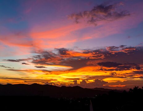 Dramatic sunset over silhouettes of hills - Powered by Adobe