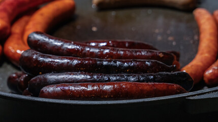 barbecue pork sausages with grilled stripes fried on a dark background