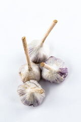 several heads of garlic lie on a light background. fresh vegetables