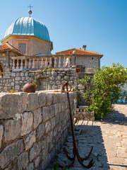 Stone walls surround a baroque-style domed church on the artificial man-made islet named Our Lady of the Rocks near Perast in the Bay of Kotor, Montenegro.