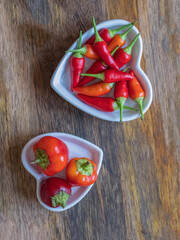 plate full of hot red peppers on wooden background with copy space