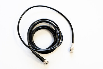 A black cable is laying on a white background