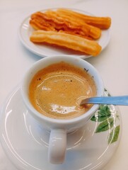 coffee with milk and churros on the table