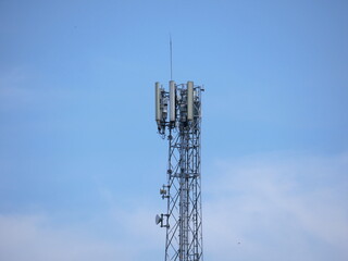 Telecommunication tower with antennas and transmitters against clear blue sky