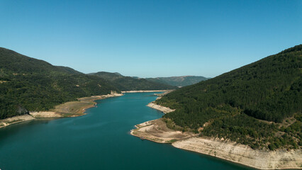 Obraz premium Aerial view of Zavoj Lake in Stara Planina National Park, Serbia, with turquoise water surrounded by green mountains