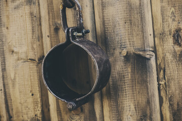 old and rusty shackles closed traditional design handcuffs hanging on a wall background
