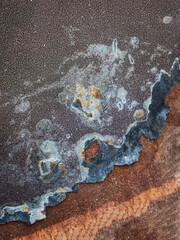 The image is of a rusty metal surface with a lot of holes and scratches. The surface appears to be old and worn, with a lot of rust and grime.