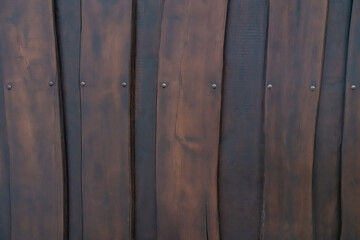 A wooden surface with a grainy texture and a few nails sticking out