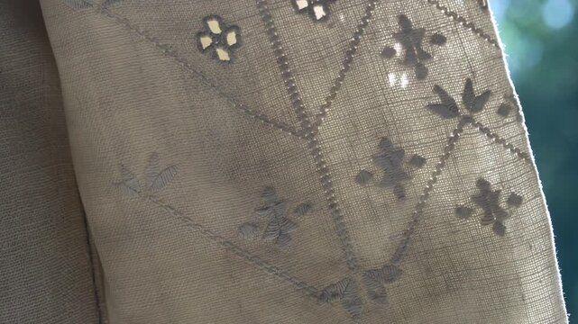 Macro. Authentic Ukrainian "white-on-white" embroidery on homespun linen: intricate cutwork, satin stitch techniques