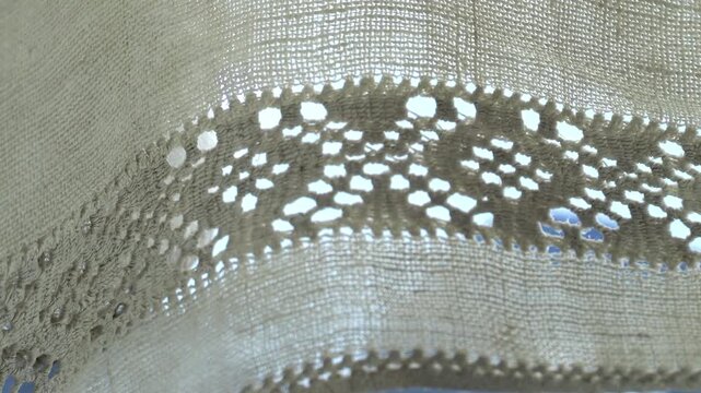 Macro of openwork embroidery on homespun linen: An ethnographic example of Ukrainian decorative art, demonstrating complex drawn-thread and cutwork techniques.