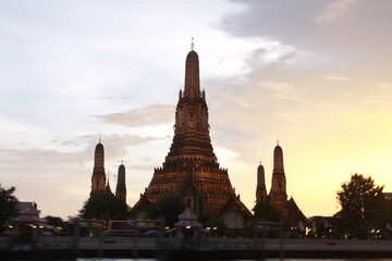 Fototapeta premium Bangkok, Thailand — City Skyline, Chao Phraya River & Temple Spires at Sunset 