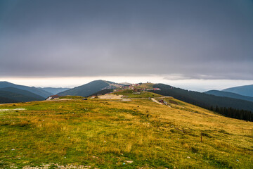 A solo traveler experiences a breathtaking autumn day in the wild Carpathian Mountains, near Lake Galcescu, in the Parang Mountains of Romania, where vibrant fall colors meet rugged peaks