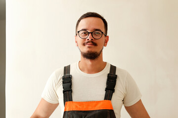 young male builder portrait beard. professional tradesman white wall. friendly plumber electrician man. construction worker modern portrait
