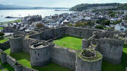Aerial view of  the medieval ruins of Beaumaris Castle and the coastal town of Beaumaris on the Isle of Anglesey in Gwynedd off the north Wales coast. The castle dates from around 1295.