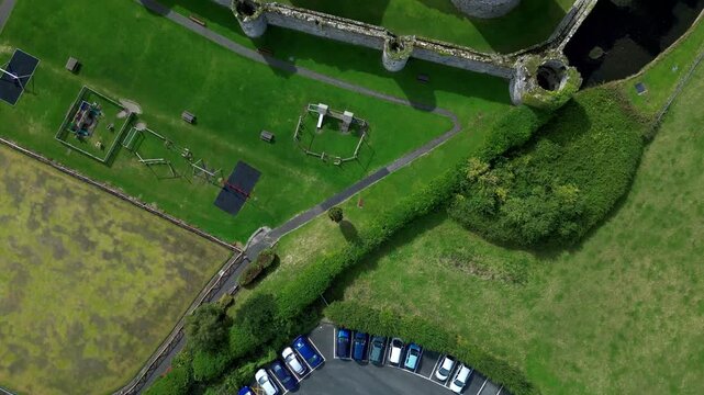 Aerial view of  the medieval ruins of Beaumaris Castle and the coastal town of Beaumaris on the Isle of Anglesey in Gwynedd off the north Wales coast. The castle dates from around 1295.