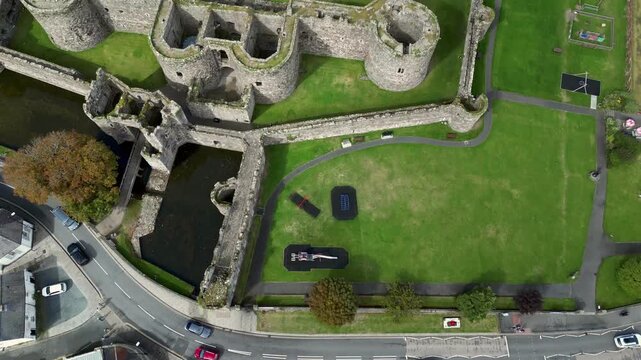 Aerial view of  the medieval ruins of Beaumaris Castle and the coastal town of Beaumaris on the Isle of Anglesey in Gwynedd off the north Wales coast. The castle dates from around 1295.