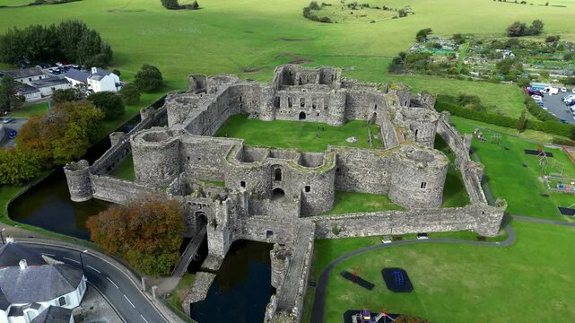 Aerial view of  the medieval ruins of Beaumaris Castle and the coastal town of Beaumaris on the Isle of Anglesey in Gwynedd off the north Wales coast. The castle dates from around 1295.