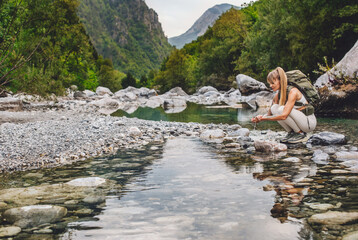 Woman Tourist Washing Hands in Mountain River