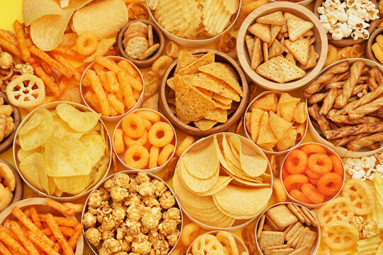 Colorful mix of salty snacks for beer varieties: chips and pretzels, rings and crackers. Non-healthy junk food background