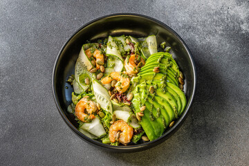 Fresh avocado and shrimp salad with cucumber and seeds