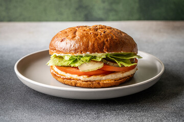 Fresh chicken burger with lettuce, tomato, and pickles