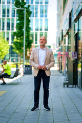 Confident middle-aged man standing a city street and looking away
