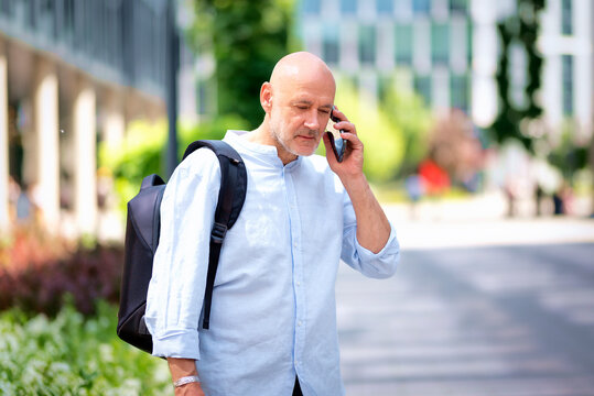 Confident middle aged man walking along a city street and sightseeing