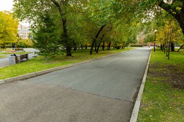 Quiet pathway in a serene park surrounded by vibrant autumn foliage, perfect for leisurely walks and enjoying nature's beauty during late afternoon