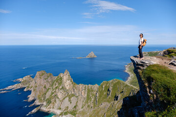 Captivating landscape of Matind Mountain in Bleik, Andoya showcasing a hiker standing on a rocky...