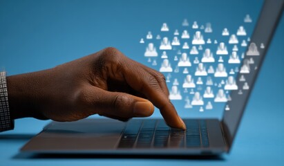 A dark-skinned hand presses a laptop key. Floating white icons of human silhouettes form a crowd above the silver-grey screen on a blue backdrop