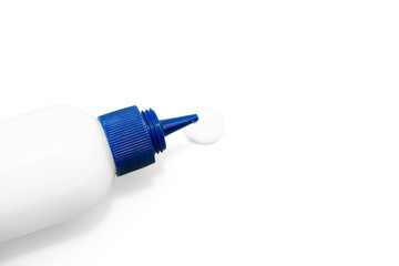 White glue bottle with blue cap dispensing a drop on textured surface close up  on a transparent Background