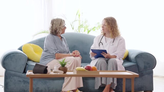 Doctor visiting elderly patient at home for medical checkup