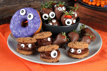 Doces decorados para festa de halloween: morangos, frutas, chocolates, cookies e donuts