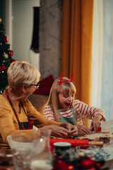 Grandmother and granddaughter making christmas cookies together