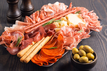 Charcuterie board. Antipasti appetizers of meat platter with salami, prosciutto crudo or jamon and olives.