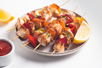 Delicious grilled chicken skewers with capsicum, lemon, salad and ketchup on a plate over the table. Chicken kebab. Healthy food concept.