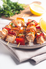 Delicious grilled chicken skewers with capsicum, lemon, salad and ketchup on a plate over the table. Chicken kebab. Healthy food concept.