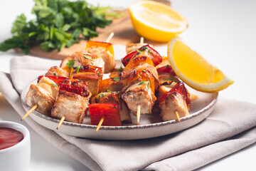 Delicious grilled chicken skewers with capsicum, lemon, salad and ketchup on a plate over the table. Chicken kebab. Healthy food concept.