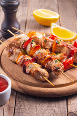 Delicious grilled chicken skewers with capsicum, lemon, salad and ketchup on a plate over the table. Chicken kebab. Healthy food concept.