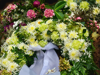 Trauer am Grab mit vielen schönen zarten Blumen Gestecken, ohne Namen