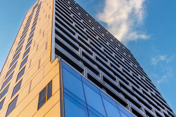 Modern skyscraper with geometric facade against blue sky