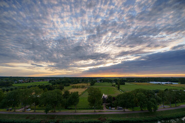 Obraz premium Breathtaking balcony view overlooking the lush green fields of Holland's countryside during a stormy summer sunset near Amsterdam, Netherlands