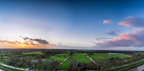 Breathtaking balcony view overlooking the lush green fields of Holland's countryside during a stormy summer sunset near Amsterdam, Netherlands