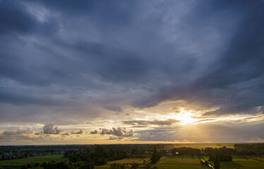 Breathtaking balcony view overlooking the lush green fields of Holland's countryside during a stormy summer sunset near Amsterdam, Netherlands