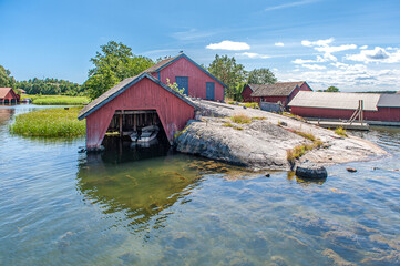 Traditional red boat houses at Harstena island in the Baltic Sea. The former fishing village in the Swedish archipelago of Gryt is now a popular tourist destination.