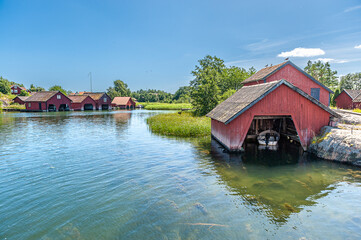 Traditional red boat houses at Harstena island in the Baltic Sea. The former fishing village in the Swedish archipelago of Gryt is now a popular tourist destination.